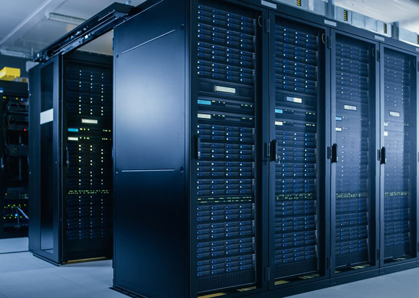 Rows of server racks inside a secure data center facility with enterprise IT infrastructure.